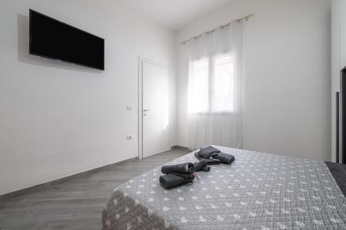 a bedroom with a bed and a flat screen tv at Casa Manu in Assemini