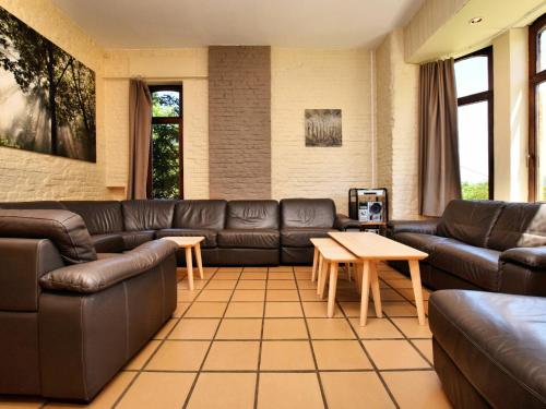 een woonkamer met leren banken en een tafel bij Cozy Cottage in Durbuy with Garden in Barvaux