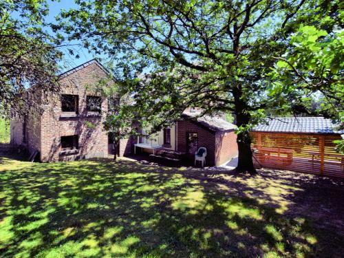 una casa con un árbol delante de un patio en Cozy Cottage in Durbuy with Garden, en Barvaux