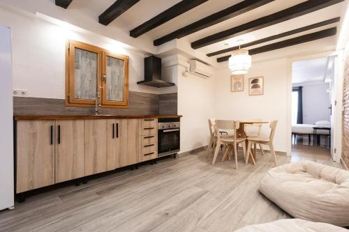 a kitchen with wooden cabinets and a table with chairs at HOSTAL BEDMATES in Barcelona