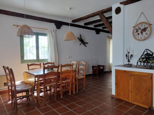 eine Küche und ein Esszimmer mit Tisch und Stühlen in der Unterkunft Casa Rural Las Adelfas in Cómpeta