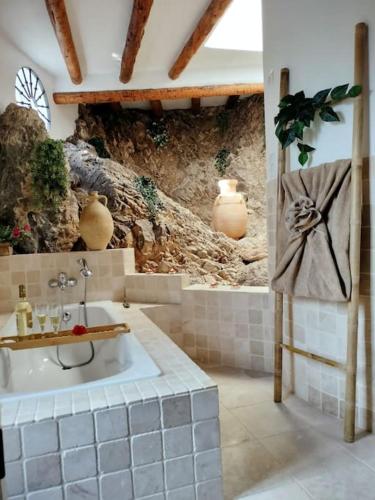 a bathroom with a sink and a stone wall at Casa Rural Las Adelfas in Cómpeta