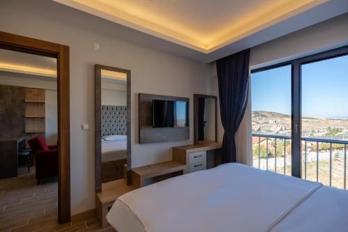 ein Schlafzimmer mit einem großen Bett und einem Balkon in der Unterkunft Afyon Regulus Thermal Apart Hotel & Villas in Gazligol