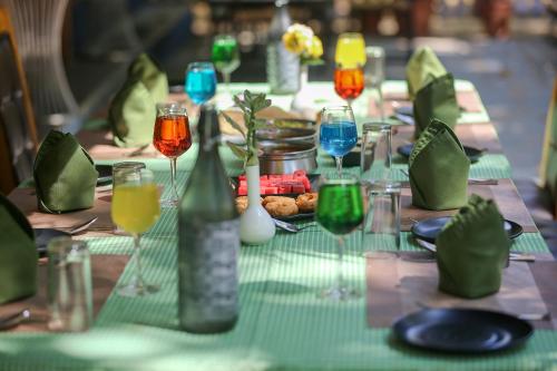 a table with a green table cloth with wine glasses at Pench Wilderness Camp Resort in Khawāsa