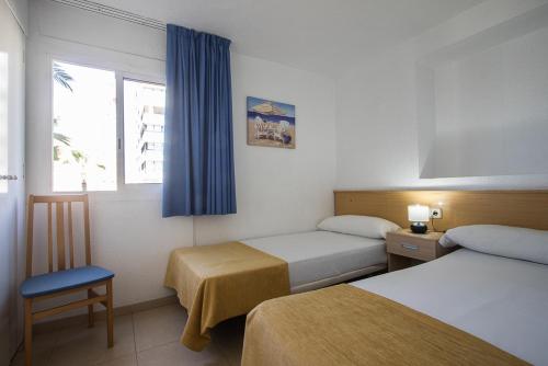 a hotel room with two beds and a window at Apartamentos Torre Yago in Benidorm