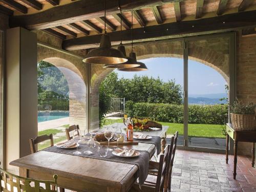 een eetkamer met een tafel en uitzicht op een zwembad bij Ritzy Villa on a Wine Estate in Arezzo with Pool in Arezzo