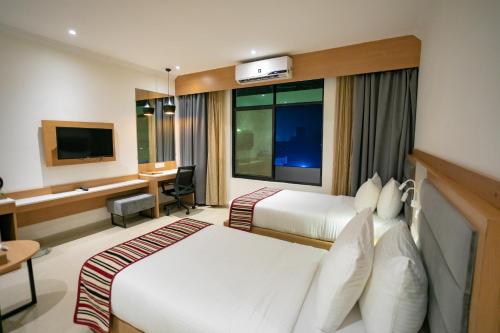 um quarto de hotel com duas camas e uma secretária em Hotel Starlight em Nepālganj