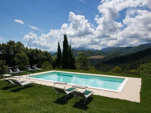 uma piscina com cadeiras e vista para as montanhas em Pretty Holiday Home in Acqualagna with Swimming Pool em Acqualagna