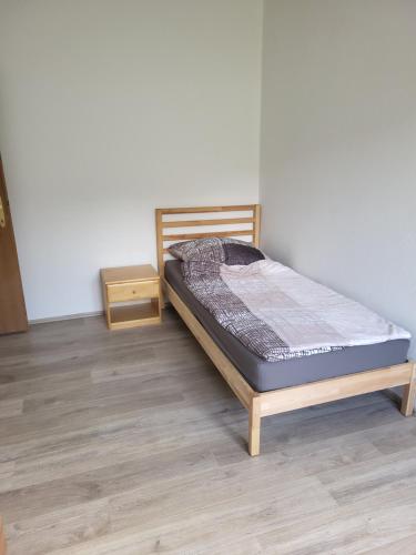 1 dormitorio con 1 cama y suelo de madera en Schöne 2 zwei Zimmer Wohnung, en Gleisdorf