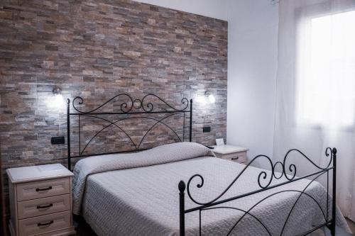 a bedroom with a bed and a brick wall at Mare Sole in San Teodoro