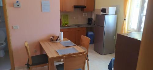 una pequeña cocina con mesa de madera y nevera. en Apartments Ivka, en Omiš