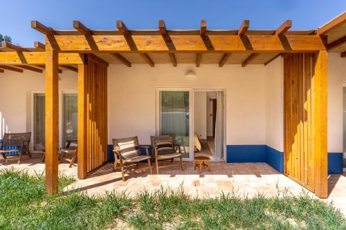 eine Terrasse mit einer hölzernen Pergola in der Unterkunft Vale da Cassiopeia in Cercal