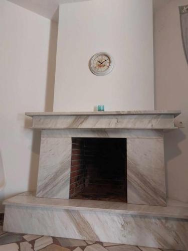 a fireplace in a room with a clock on the wall at Studio με όλες τις ανέσεις in Néon Petrítsion