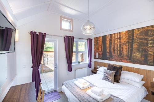 a small bedroom with a bed and a window at Hedgehog Lodge with Hot Tub in Cupar