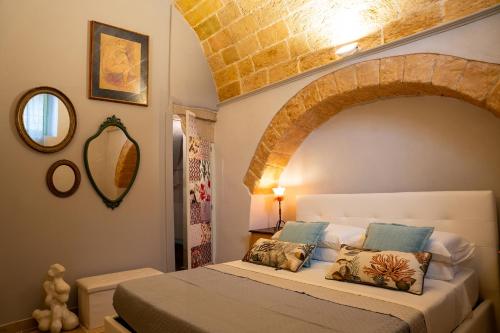 - une chambre avec un lit et un plafond voûté dans l'établissement LITHOS guest room, à Barletta