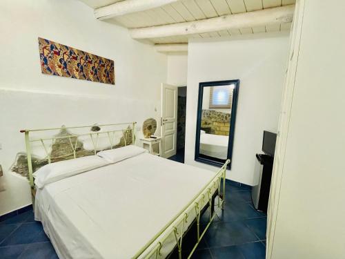 1 dormitorio con cama blanca y espejo en Borgo Camicia In, en Barcellona-Pozzo di Gotto