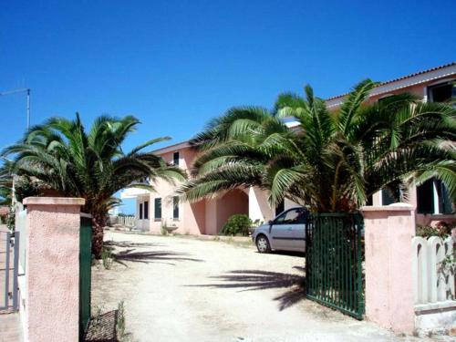 a car parked in front of a house with palm trees at Modern Apartment in Valledoria with Swimming Pool in Codaruina