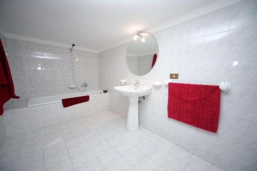 a white bathroom with a sink and a red towel at CIRASA in Trapani