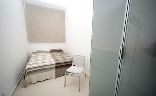 a small room with a bed and a chair at CIRASA in Trapani