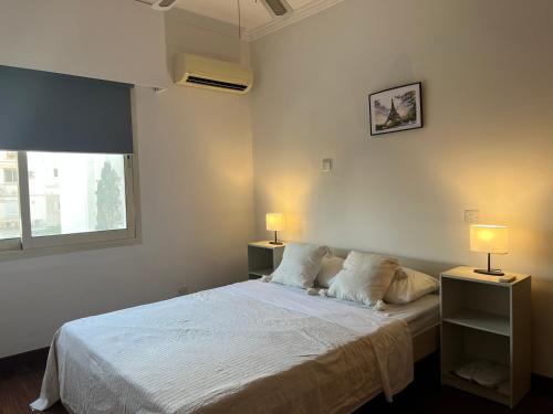 - une chambre avec un lit blanc et deux lampes dans l'établissement SEA VIEW AMATHUS LUXURY APT, à Limassol