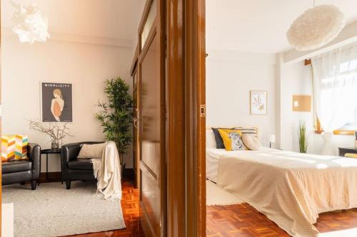 a bedroom with a bed and a couch and a chair at VibesCoruna - Outeiro 222 in A Coruña
