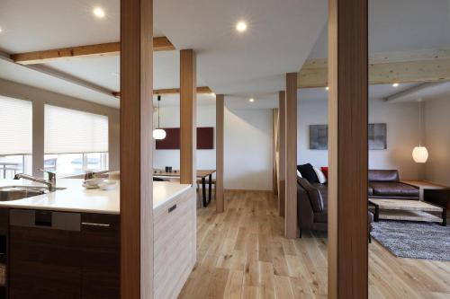 a kitchen and living room with a couch and a table at AKATSUKI in Furano