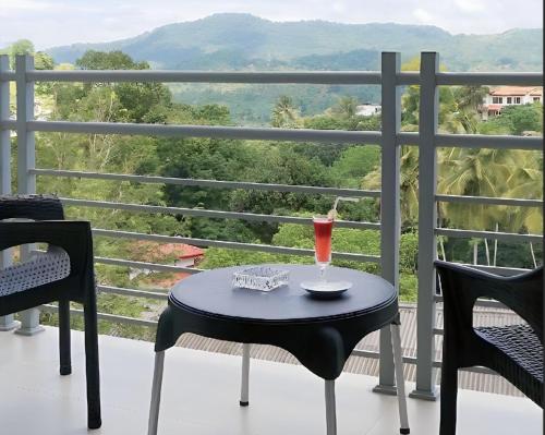 a drink sitting on a table on a balcony at Regent Heights in Kandy