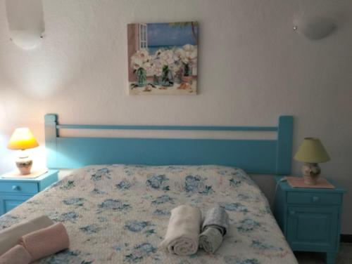 a bedroom with a blue bed with towels on it at Casa Rosa 