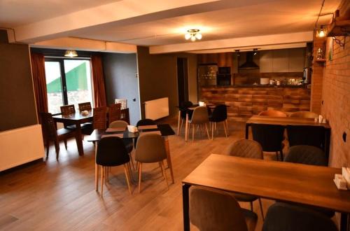 a restaurant with tables and chairs in a room at Kazbegi 4U in Stepantsminda