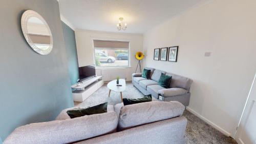 a living room with two couches and a mirror at Daventry House Stockton by Horizon Stays in Stockton-on-Tees