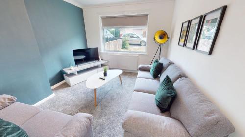 a living room with a couch and a tv at Daventry House Stockton by Horizon Stays in Stockton-on-Tees
