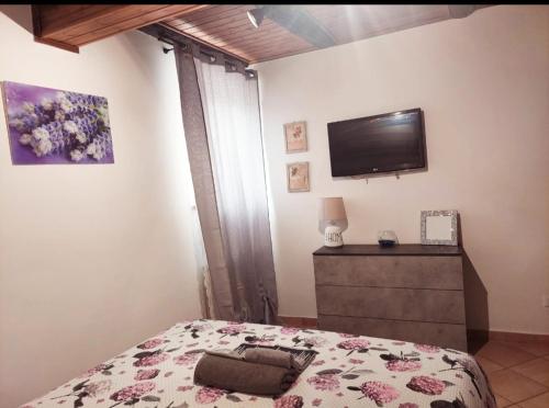 - une chambre avec un lit et une télévision murale dans l'établissement Le Casette Nel Borgo, à Nepi