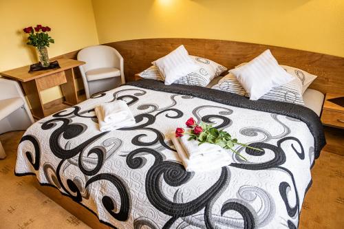 a bed with a black and white comforter with flowers on it at Apartmán u Vierky in Veľká Lomnica