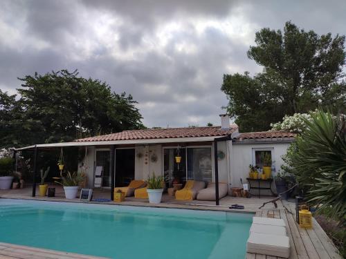 a house with a swimming pool in front of it at B&B La Terre Brûlée in Aigues-Mortes