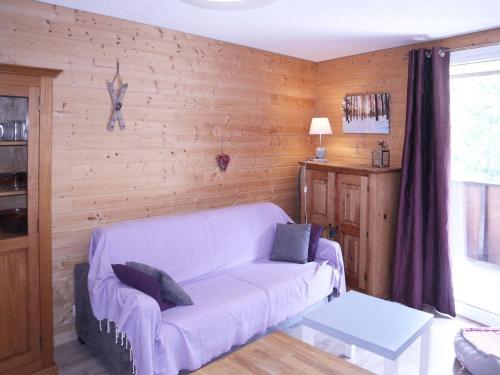 a living room with a couch and a wooden wall at Studio Les Orres, 1 pièce, 4 personnes - FR-1-322-339 in Les Orres