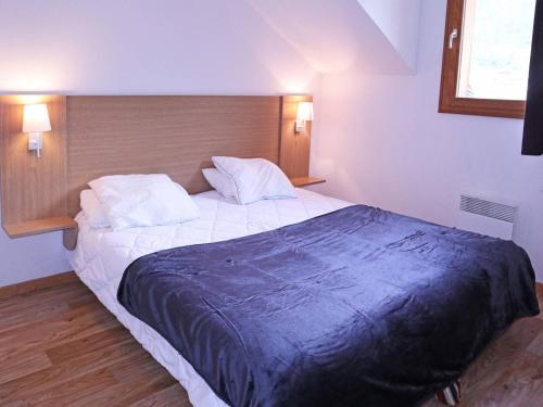 una camera da letto con un grande letto con una coperta blu sopra di Appartement Les Orres, 3 pièces, 8 personnes - FR-1-322-206 a Les Orres
