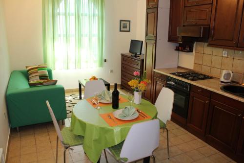 a kitchen with a table and a green table and chairs at Apartments Stari Šibenik in Grebaštica