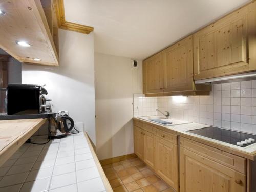une cuisine avec des armoires en bois et un évier dans l'établissement Sublime appartement 58m² Courchevel 1850 - 4/5 pers - Proche pistes, déco soignée, wifi, skis - FR-1-631-87, à Courchevel