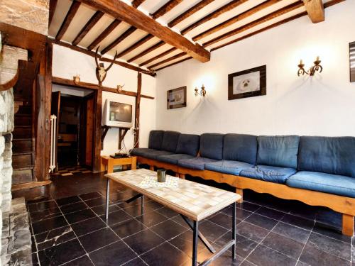 Villers-Sainte-GertrudeにあるLavish Holiday Home in Durbuy with Saunaのリビングルーム(青いソファ、テーブル付)
