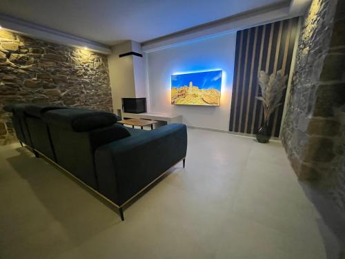 a living room with a couch and a television at Villa Copun with heated pool in Rab