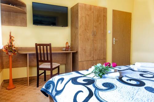 a bedroom with a bed and a desk with a television at Apartmán u Vierky in Veľká Lomnica