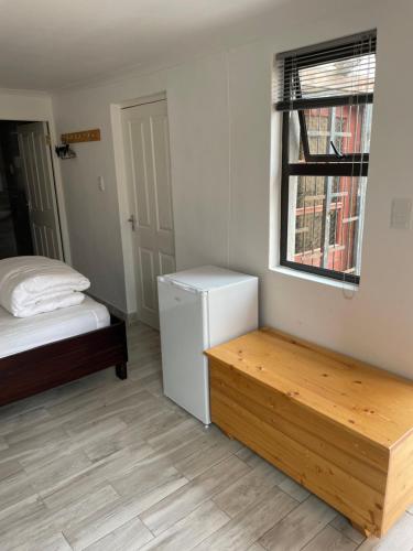 um quarto com uma cama, uma secretária e uma janela em The Oasis Accommodation em Lüderitz