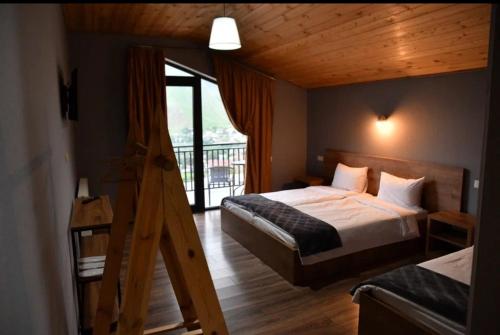 a hotel room with a bed and a balcony at Kazbegi 4U in Stepantsminda