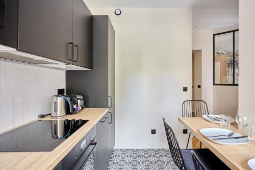 - une cuisine avec un comptoir en bois et une table dans l'établissement Apartment Invalide by Studio prestige, à Paris