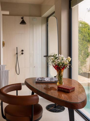 a table with a vase of flowers and a chair at La Fiermontina Luxury Home Hotel in Lecce