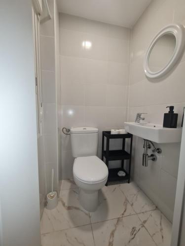 biała łazienka z toaletą i umywalką w obiekcie Piso en el centro de Madrid w Madrycie