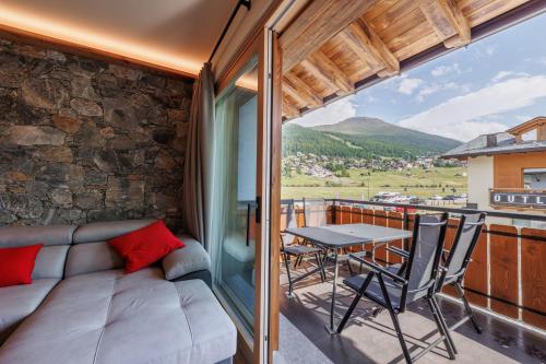 a living room with a couch and a table on a balcony at Stella Del Nord - Livigno Centro in Livigno