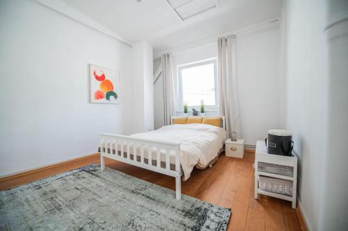 a white bedroom with a bed and a window at 150qm LOFT, Tischtennis, Dart, Tischkicker in Hamburg
