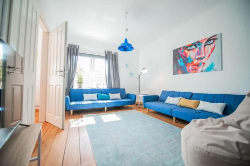 a living room with blue couches and a blue rug at 150qm LOFT, Tischtennis, Dart, Tischkicker in Hamburg