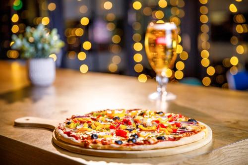 a pizza on a table with a glass of wine at ibis Nottingham Centre in Nottingham